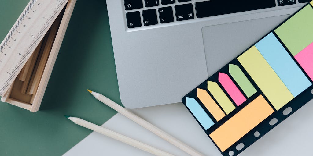 An artistic flat lay of a desk with a laptop open to an email interface, surrounded by sticky notes with reminders and a coffee cup. One sticky note prominently features the phrase 'Bumping This Up!' in bold letters, emphasizing the theme of prioritizing communication.