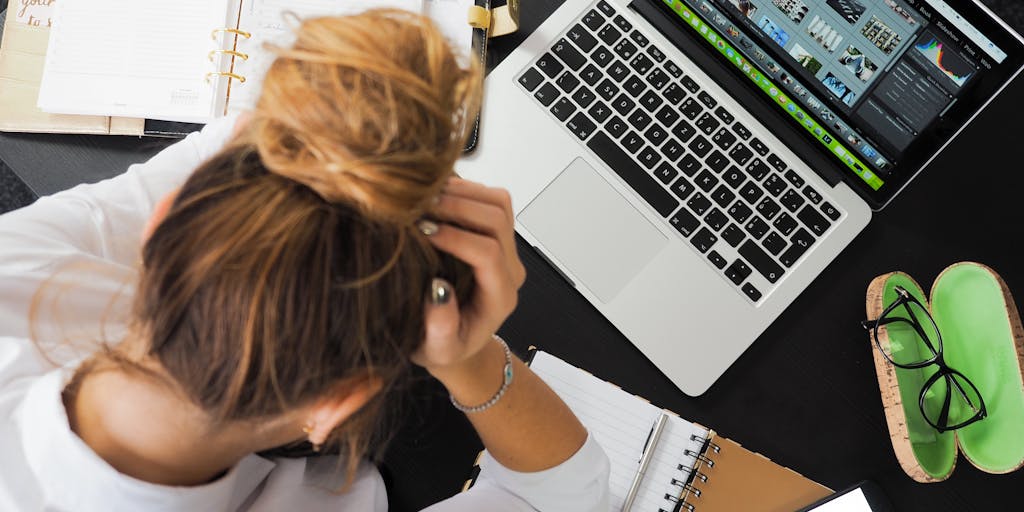 A split image showing two contrasting scenes: on one side, a business person looking stressed while reviewing declining KPIs on a computer screen; on the other side, the same person celebrating a successful KPI report with colleagues. This visual metaphor highlights the highs and lows of business development.