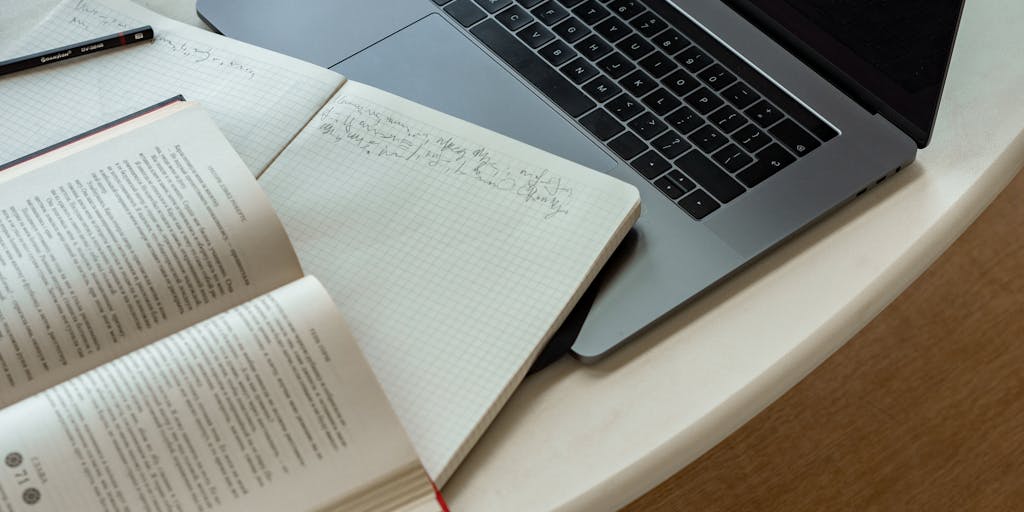 A close-up shot of a broken heart made of paper, with a laptop in the background displaying an email draft. The heart symbolizes the emotional aspect of a sales break-up, while the laptop represents the digital communication involved.