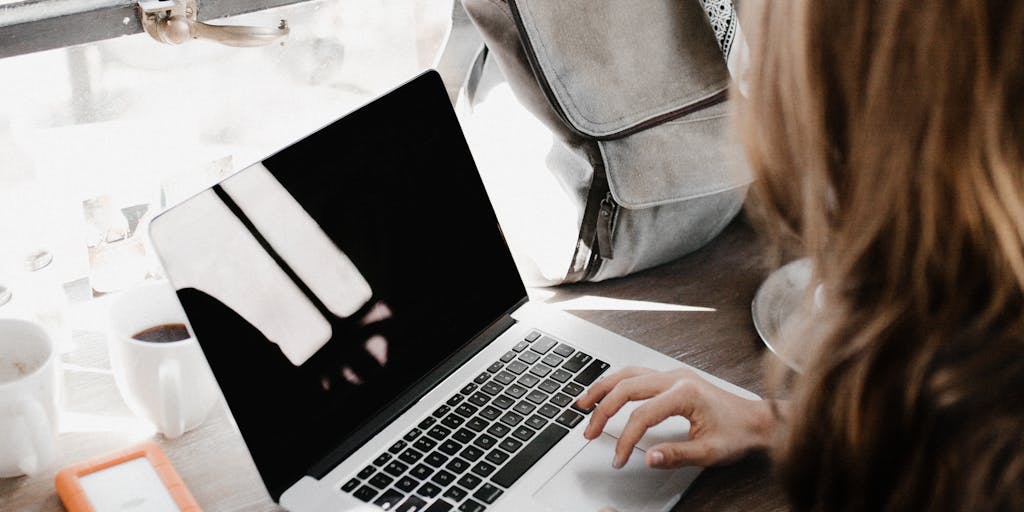 A person sitting at a desk, looking thoughtfully at a computer screen showing the Systeme.io website. The background should include motivational posters about entrepreneurship and digital marketing, creating an inspiring environment.