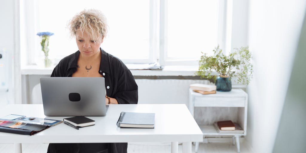 A dynamic image of a person sitting at a desk, excitedly interacting with the Dripify platform on their laptop. The background should be filled with motivational quotes and a vision board, showcasing the journey of growth and success.
