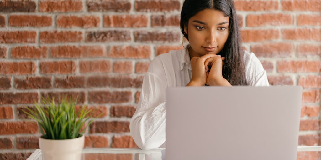 A close-up shot of a person using a laptop with Smartlead's interface displayed on the screen. The background features a cozy home office setup with plants and motivational quotes on the wall, creating a productive atmosphere.