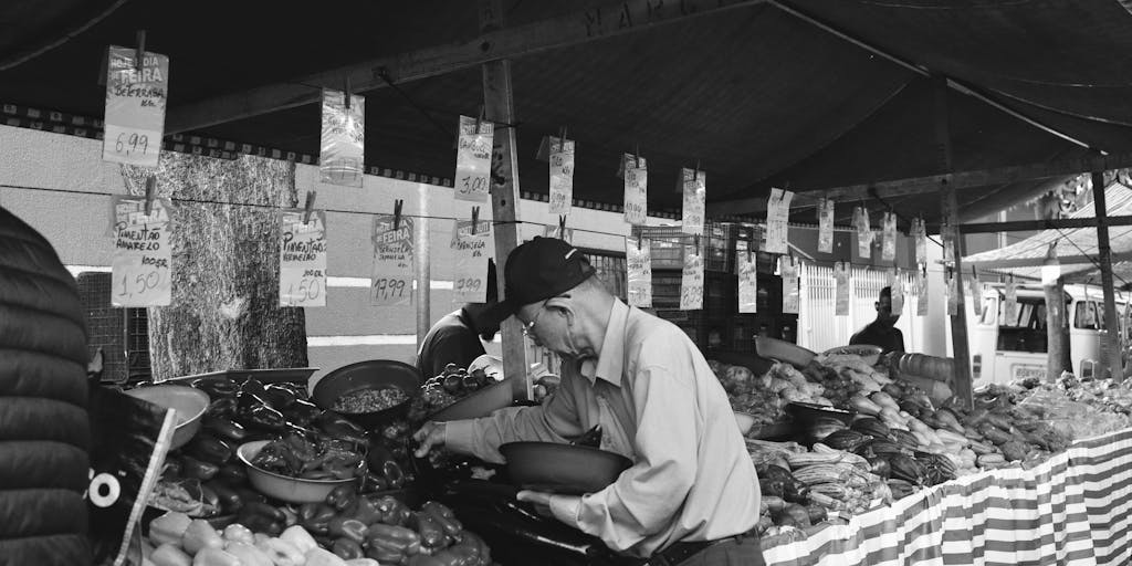 A vibrant street market scene where vendors are showcasing their products with clear, creative pricing signs. The photo captures the interaction between vendors and customers, illustrating the concept of outreach pricing in a real-world, community-focused environment.