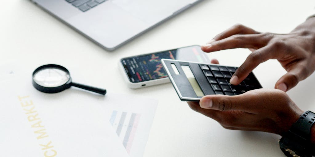 A conceptual image of a hand holding a magnifying glass over a price tag, symbolizing the scrutiny and analysis involved in outreach pricing. The background features blurred images of people engaging in discussions, representing the outreach aspect of pricing strategies.