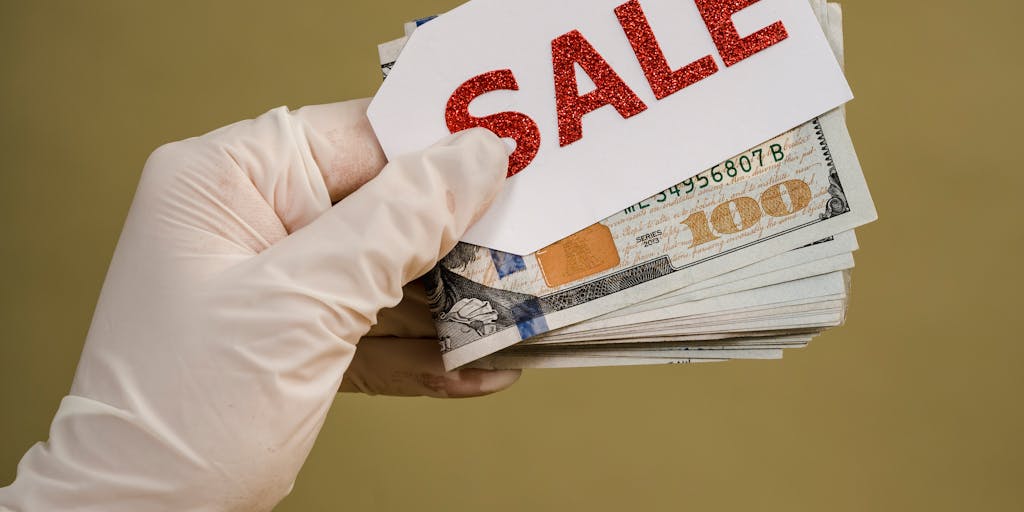 A creative image of a person holding a large, colorful price tag that is dripping paint, symbolizing the dynamic nature of pricing. The background features a vibrant street mural, adding an urban and modern feel to the concept of pricing.