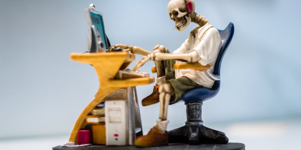 A close-up shot of a rocket model placed on a desk with a laptop open to the Rocket Reach pricing page. The background features a blurred office environment, symbolizing the connection between technology and business growth.