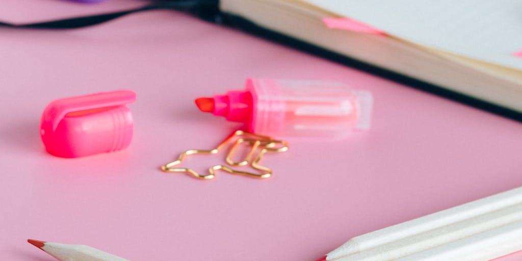 A creative flat lay featuring a calculator, a notepad with pricing calculations, and a laptop displaying the Mailmeteor pricing options. The items are arranged artistically with colorful stationery, symbolizing the analytical side of choosing the right email marketing plan.