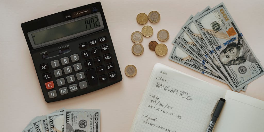 A close-up shot of a calculator with a hand pressing buttons, surrounded by scattered coins and dollar bills, symbolizing the calculation of Egrabber pricing. The background should be softly blurred to emphasize the calculator and money.