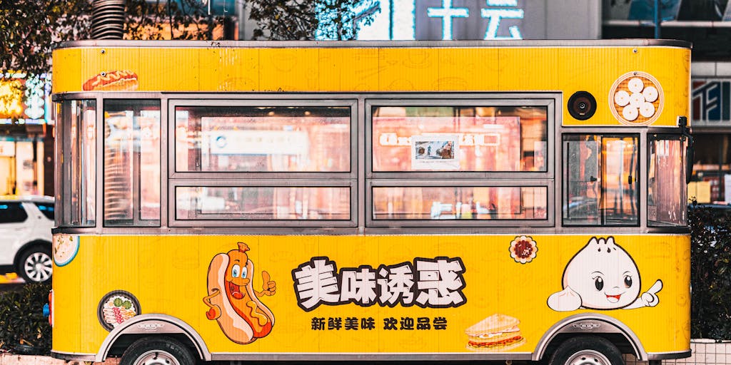 A whimsical illustration of a food truck labeled 'Yamm' parked in a bustling city street. The truck has a large menu board showcasing different pricing options, and happy customers are interacting with the staff, highlighting the value and excitement of the offerings.