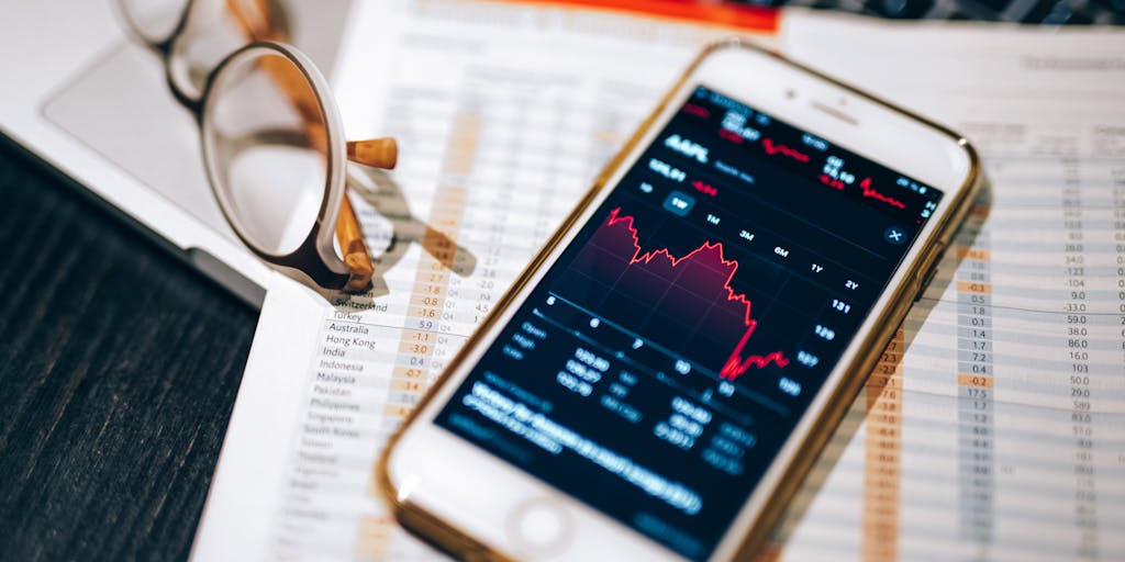 A close-up of a hand holding a smartphone with a pricing app open, showing personalized pricing options based on user preferences. The background is blurred to emphasize the phone, highlighting the concept of hyper-personalization in pricing.