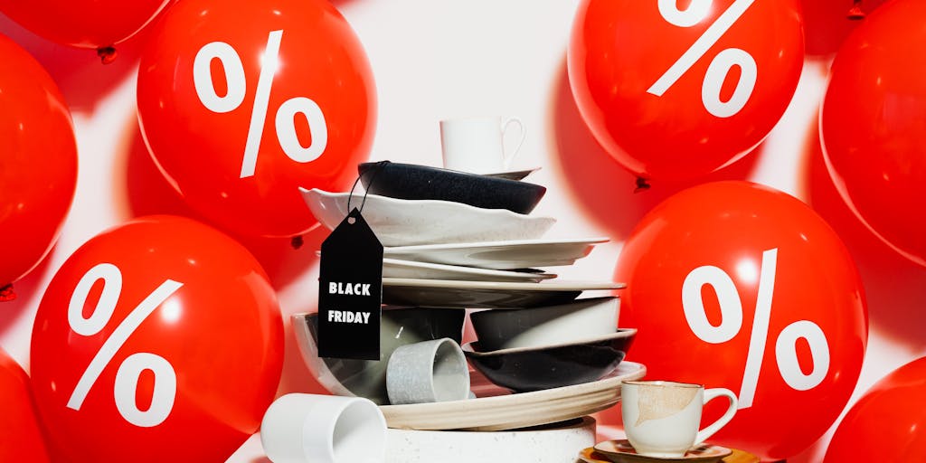 An overhead view of a shopping cart filled with various products, each with a different price tag showing streaks of color. The cart is placed on a wooden surface, and the lighting highlights the contrast between the products and their prices.