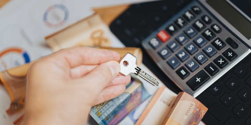 A creative flat lay of various currency notes and coins arranged in a way that forms a pie chart, representing the concept of pricing. The background is a textured surface that adds depth, and a small sign that reads 'Pipl Pricing' is included to tie the theme together.