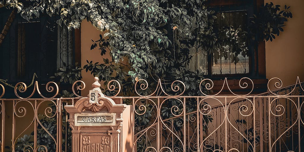 A close-up shot of a vintage mailbox with a bright yellow canary perched on top, symbolizing the concept of 'Canary Mail'. The mailbox is adorned with price tags that display various pricing tiers, creatively illustrating the pricing structure. The background features a sunny garden to evoke a cheerful and inviting atmosphere.