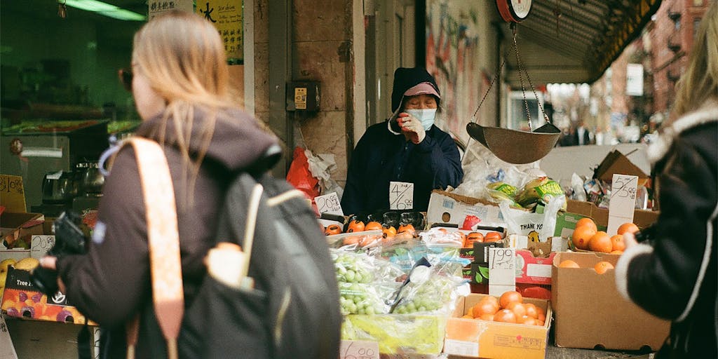 A conceptual image of a scale balancing two different price tags, one labeled 'Value' and the other 'Cost'. The background is a blurred marketplace scene, representing the balance businesses must find in pricing their products.