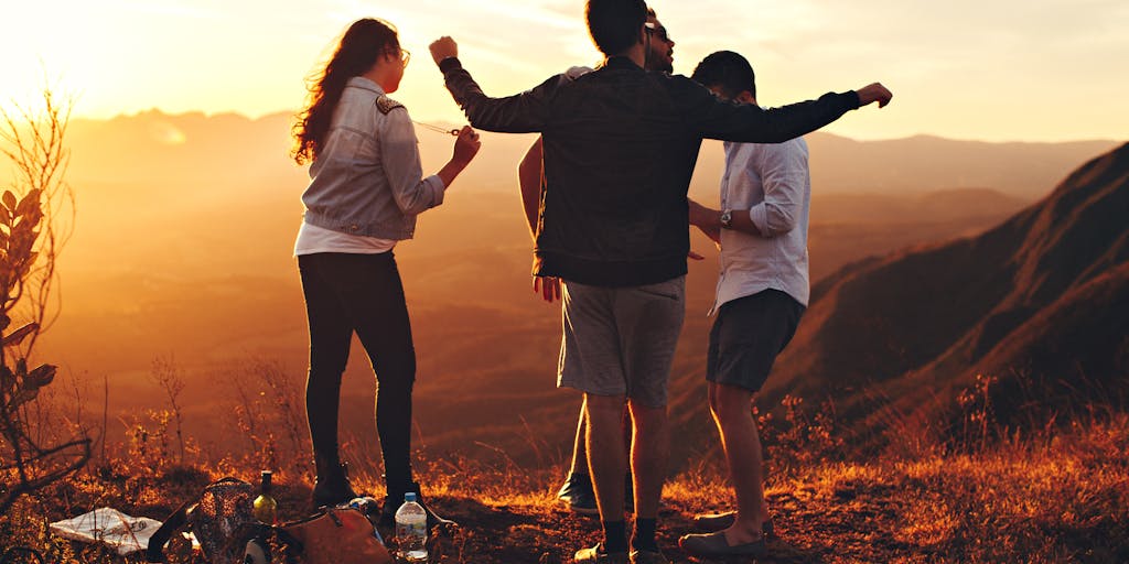 A dynamic shot of a group of friends hiking on a trail, with one person checking the Rei Reply Pricing on a tablet. The excitement of the hike is captured in their expressions, while the tablet screen is slightly visible, showcasing the pricing information. The lush greenery of the trail adds to the sense of adventure.