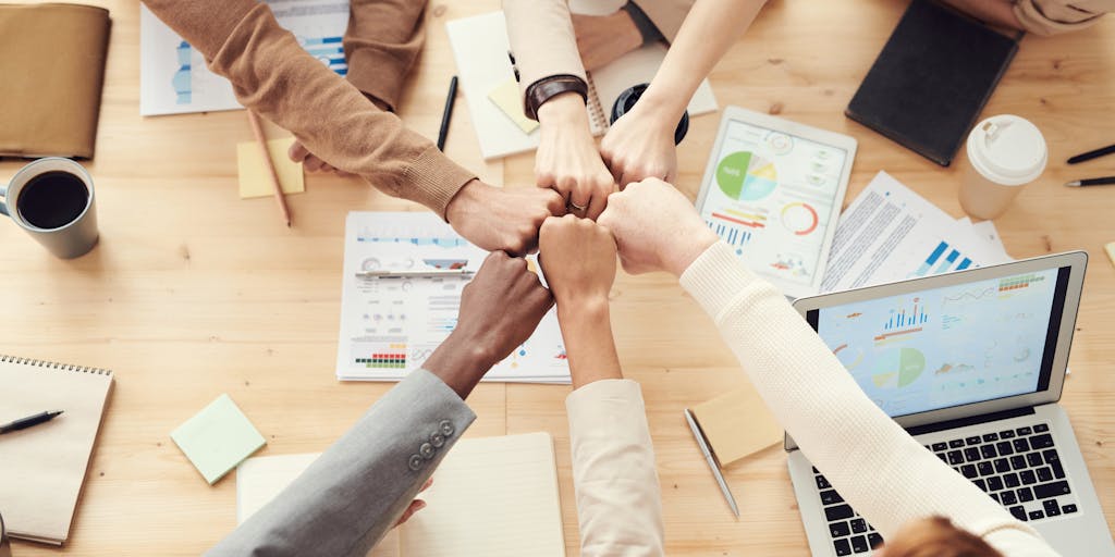 A creative shot of a group of diverse professionals gathered around a table, discussing their LinkedIn profiles and sharing tips. The atmosphere is collaborative, showcasing the importance of networking in a modern work environment.