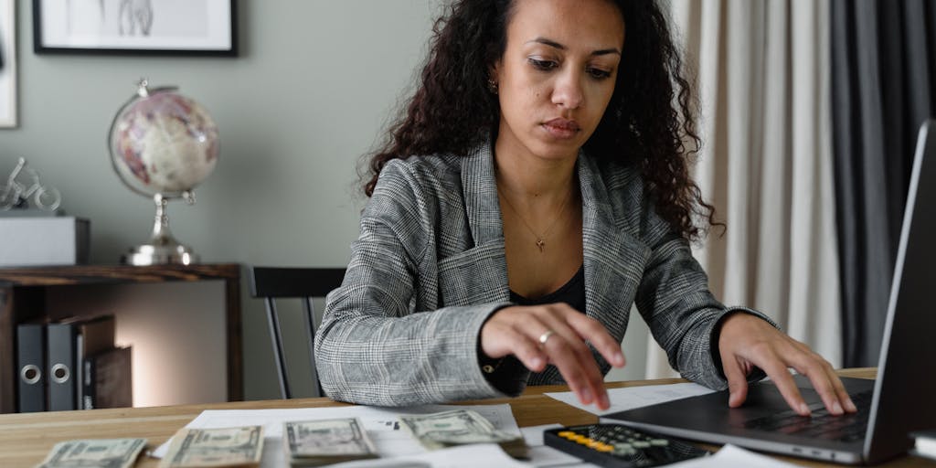 A close-up shot of a person typing on a laptop with a visible screen showing a LinkedIn post editor. The screen displays a character count meter, with the count nearing the limit. The background is blurred to emphasize the screen and the person's focused expression.