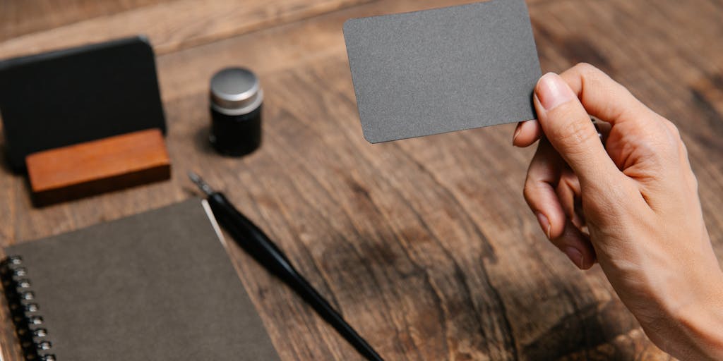 An overhead view of a desk cluttered with business cards, a smartphone displaying the LinkedIn app, and a notepad filled with lead generation strategies. The composition conveys the hustle of networking and the tools used to connect with potential leads.