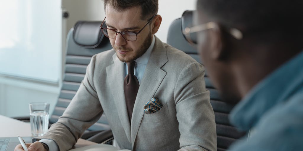 A dynamic image of a recruiter standing in front of a whiteboard filled with LinkedIn strategies and candidate profiles. The recruiter is pointing at the board, exuding enthusiasm and energy, while a team of colleagues takes notes and engages in the discussion.