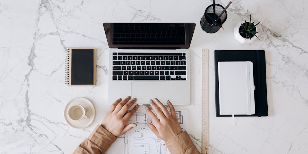 A close-up shot of a person typing on a laptop with LinkedIn open on the screen, surrounded by motivational quotes and books about personal branding. The background should be a cozy home office setting, emphasizing a productive and inspiring atmosphere.