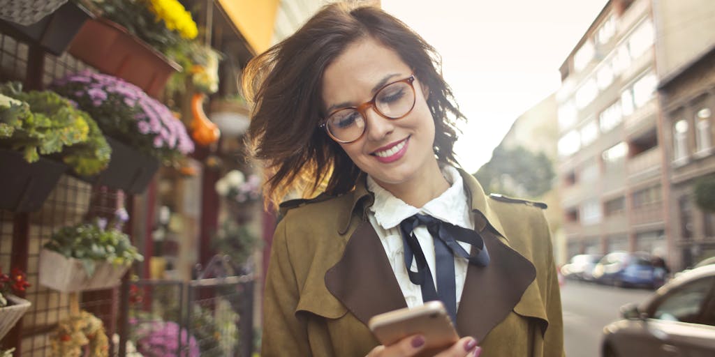 A close-up shot of a hand using a smartphone to access LinkedIn Sales Navigator, with a blurred background of a bustling cityscape. This image symbolizes the mobility and accessibility of the tool, showcasing how sales professionals can leverage it on-the-go to connect with potential leads and clients.