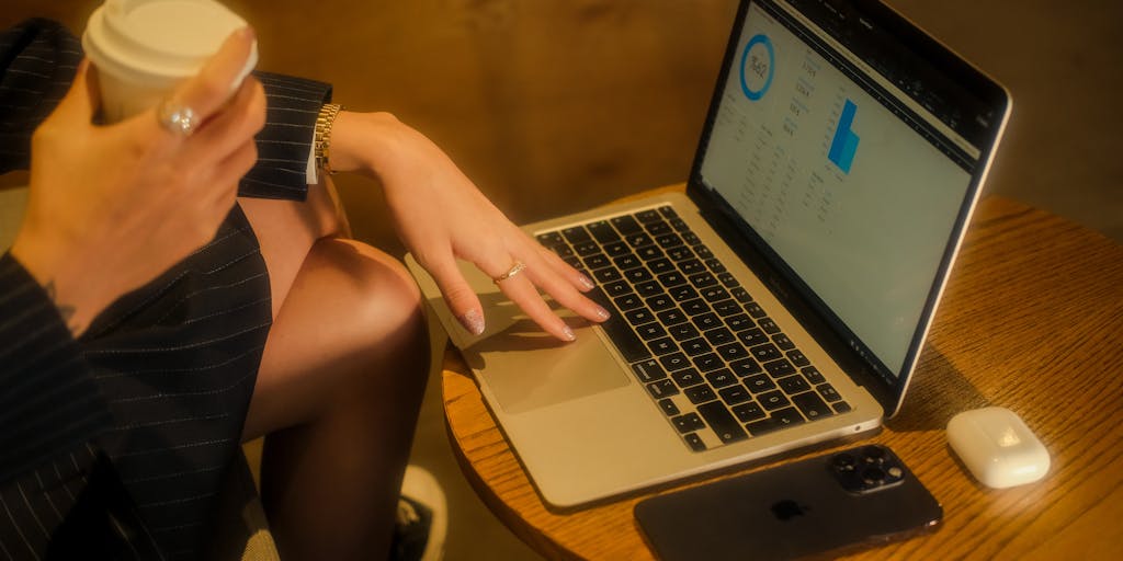 A close-up shot of a laptop screen showing the LinkedIn TeamLink Extend dashboard, with colorful graphs and connection metrics. In the background, a person is seen taking notes, symbolizing the importance of data-driven decision-making in networking.
