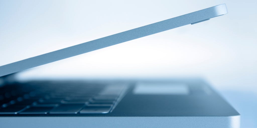 A close-up shot of a laptop screen displaying a LinkedIn profile with the 'Open to Work' feature highlighted. In the background, a person is seen thoughtfully typing on the keyboard, symbolizing the active job search process. The lighting is warm and inviting, creating a sense of hope and opportunity.