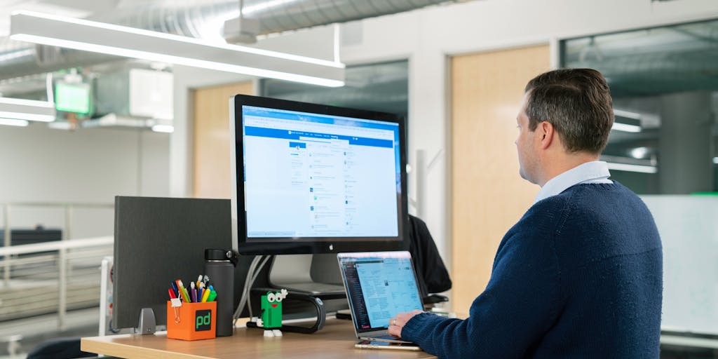 A close-up shot of a laptop screen displaying the LinkedIn Sales Navigator interface, with a focus on the Boolean search bar filled with complex search strings. The background features a blurred office environment, symbolizing a professional setting where sales strategies are developed.