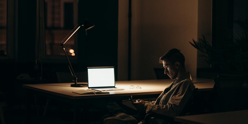 A close-up shot of a laptop screen displaying a LinkedIn profile with a highlighted message box. The background features a cozy workspace with a coffee cup and a notepad, symbolizing the casual yet professional nature of prospecting on LinkedIn.