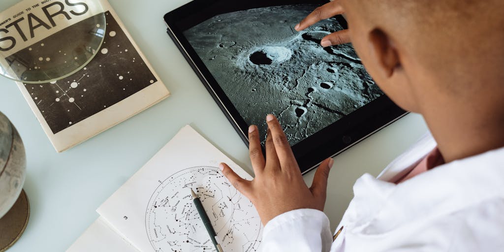 A close-up shot of a hand holding a magnifying glass over a digital tablet displaying a colorful prospecting list. The background features a blurred office setting, symbolizing the search for potential clients.