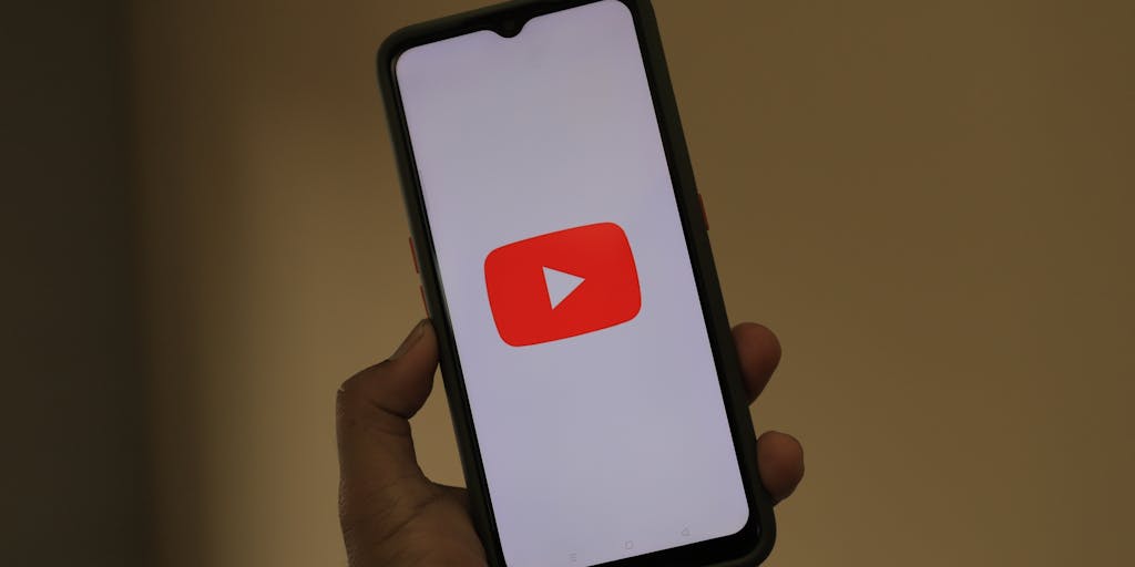 A close-up of a hand holding a smartphone displaying a social media post that promotes an outreach marketing campaign. The background features a blurred image of a busy urban environment, symbolizing the digital connection to the real world. The screen shows engaging visuals and a call-to-action, emphasizing the importance of social media in outreach efforts.