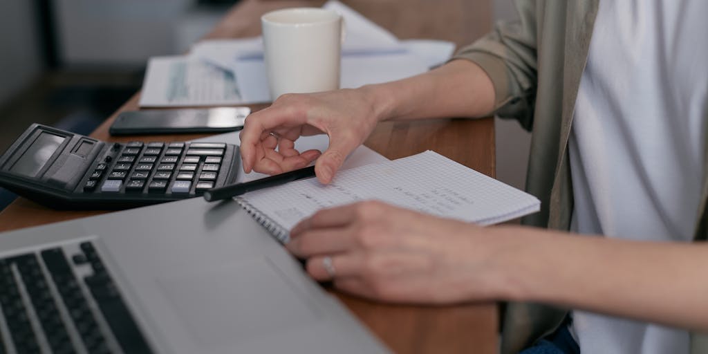 An overhead view of a desk cluttered with business cards, a laptop open to the LinkedIn Sales Navigator interface, and a notepad with handwritten notes. The scene conveys the hustle of networking and gathering contact information.
