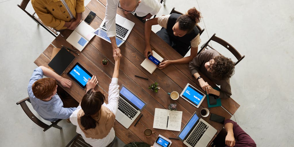 A split-screen image showing a person engaging with multiple devices simultaneously: a laptop for email, a smartphone for social media, and a tablet for video calls. The background should be a modern office space, emphasizing the concept of multichannel prospecting.